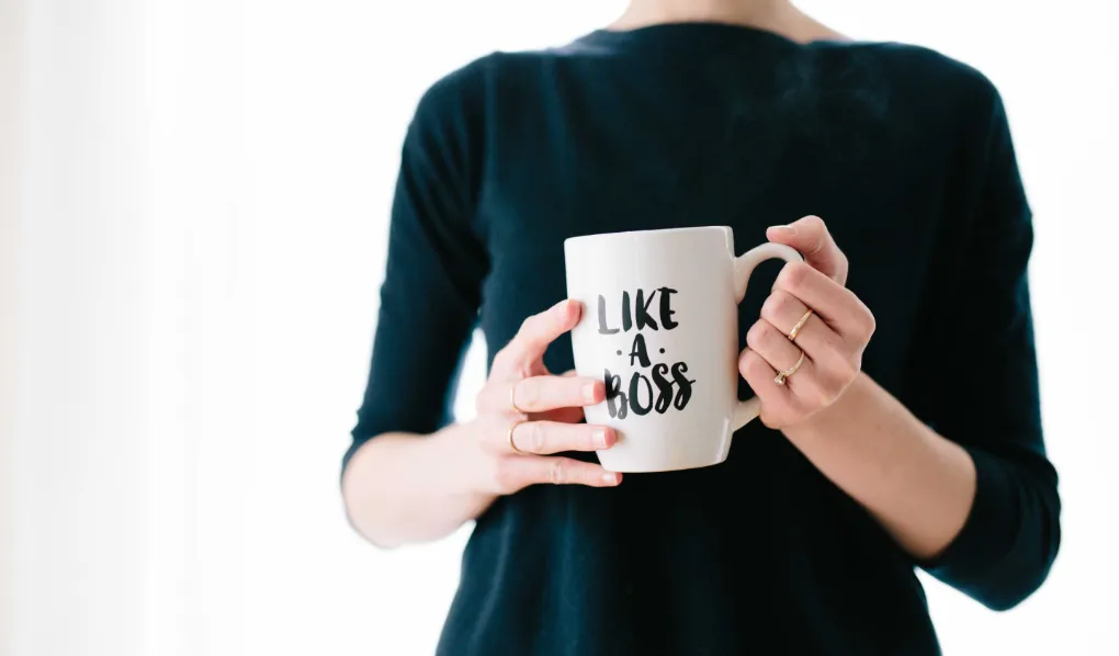 Woman holding a mug with "like a boss" on it
