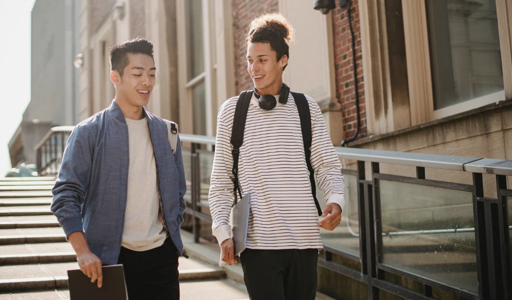 Two university students chatting and walking outside