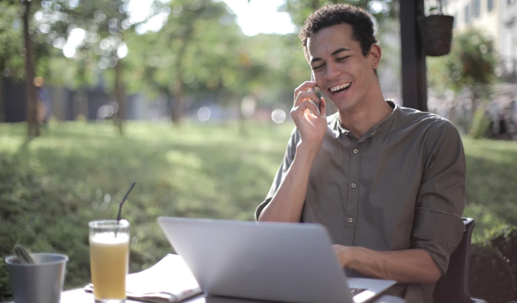 Dale sitting outside on the phone and on laptop