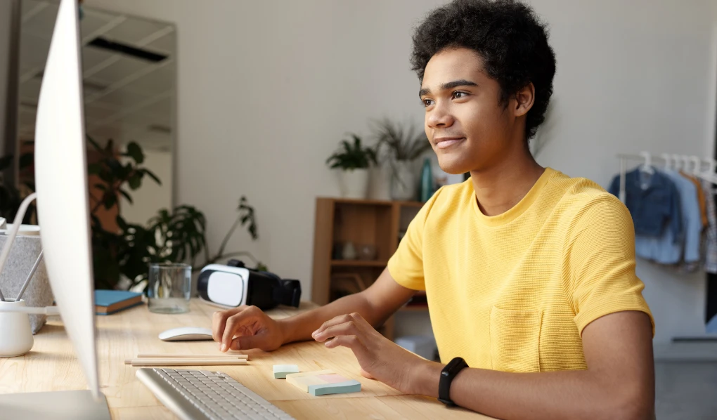 Online student checking computer and smiling