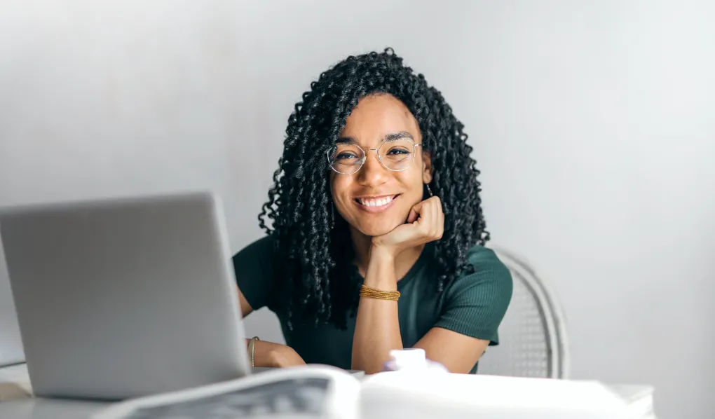 Online student upskilling online and smiling at camera