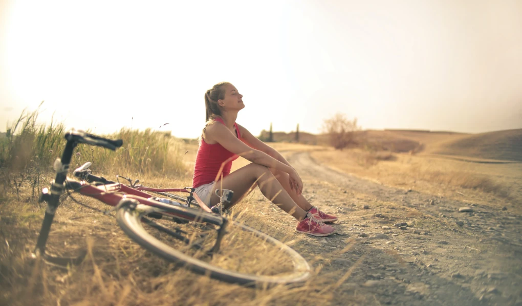 Woman taking a break from bike ride in the sunset