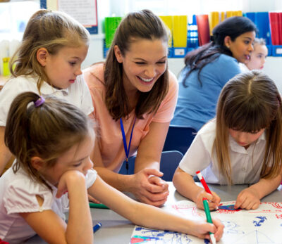 Female teacher drawing with her primary pupils