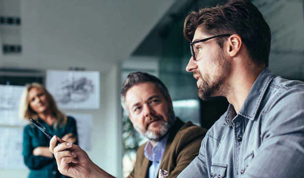 Young colleague explaining something in meeting setting