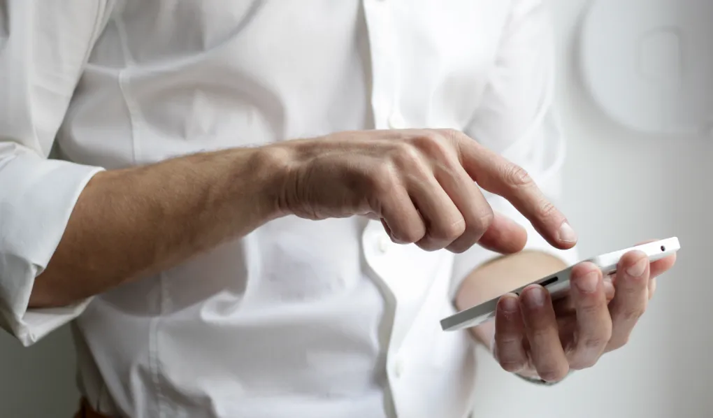 Man looking at best budgeting apps on smart phone