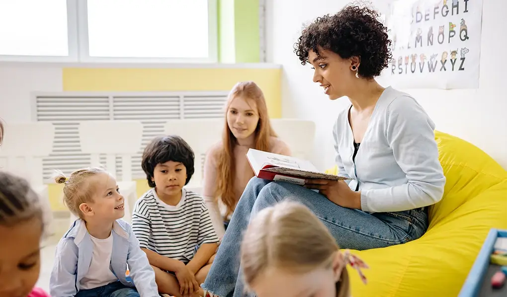 Female teacher reading to primary school kids