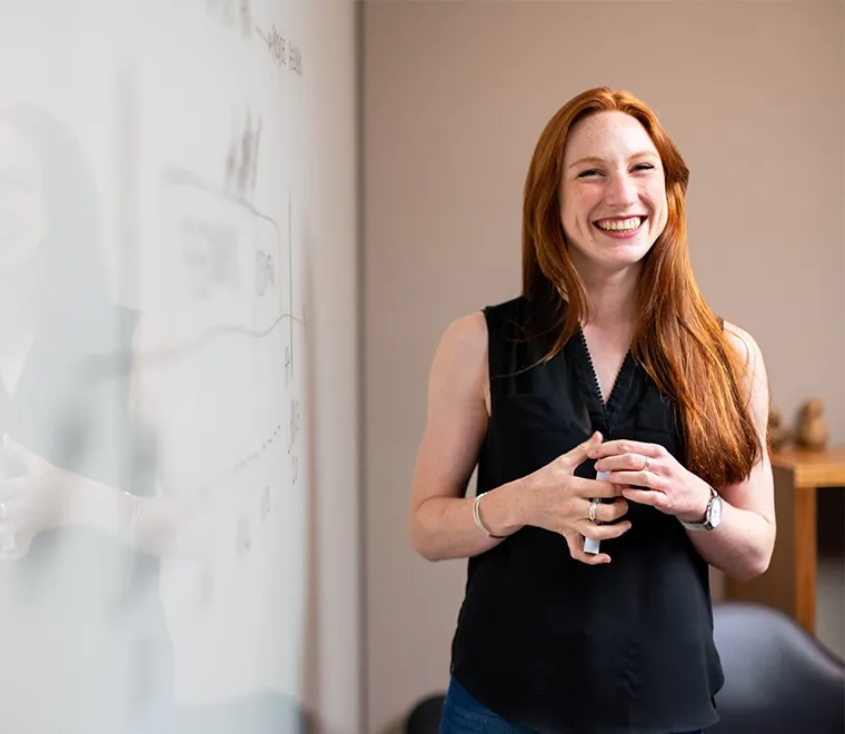 Woman standing at whiteboard