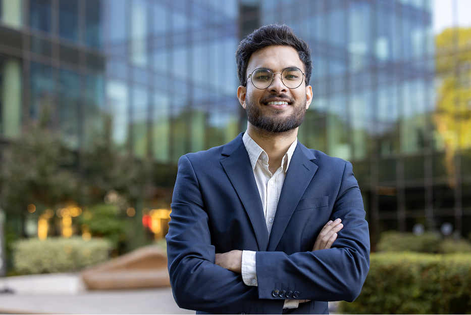Young man standing with a smile in a suit.