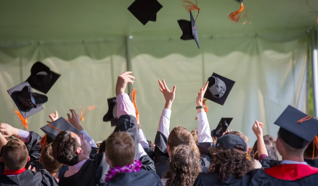 Students at graduation throwing caps