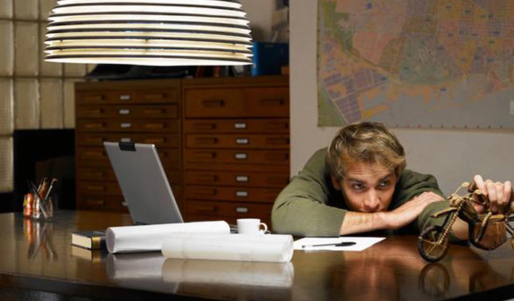 Male student playing with vintage toy while studying