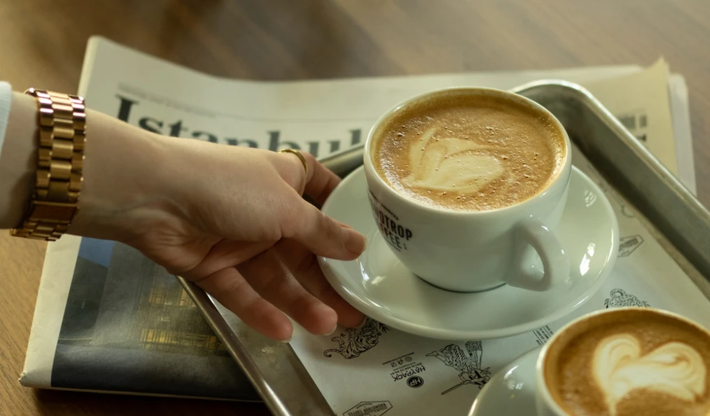 Hand reaching for coffee from tray