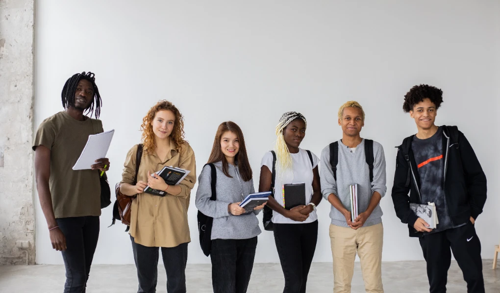 Diverse group of University students smiling with notebooks