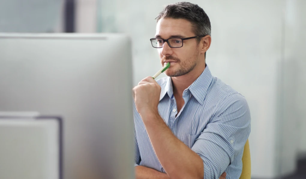 Male thinking in front of computer