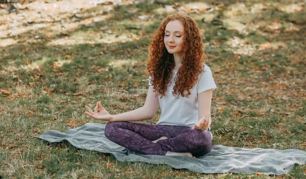 Girl meditating on the grass