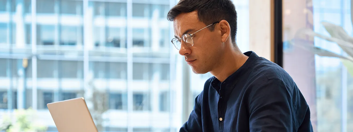 Man with glasses working on his laptop