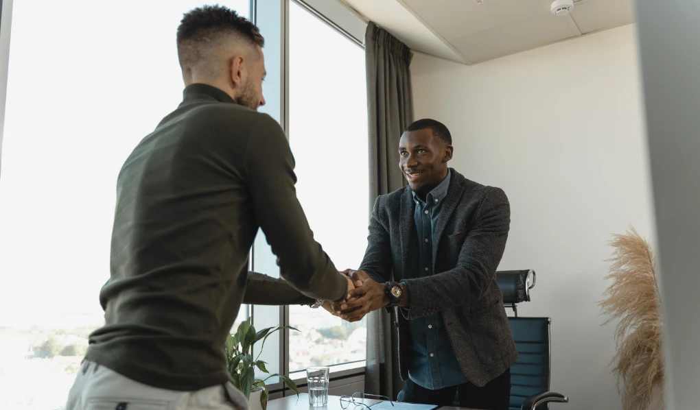 Two men shaking hands at the end of an interview