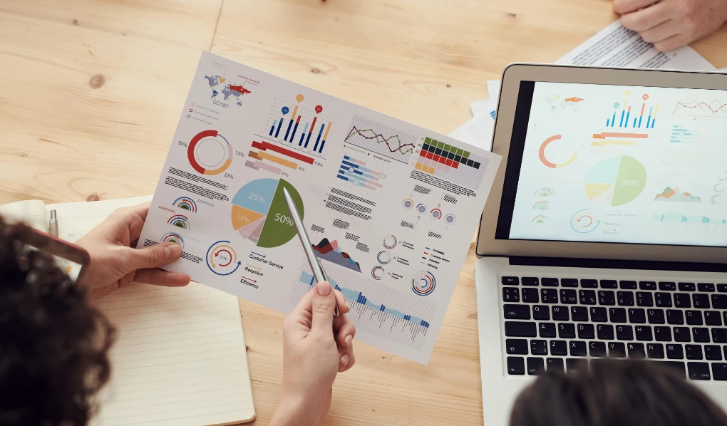 People in meeting looking at various statistics on paper and screen