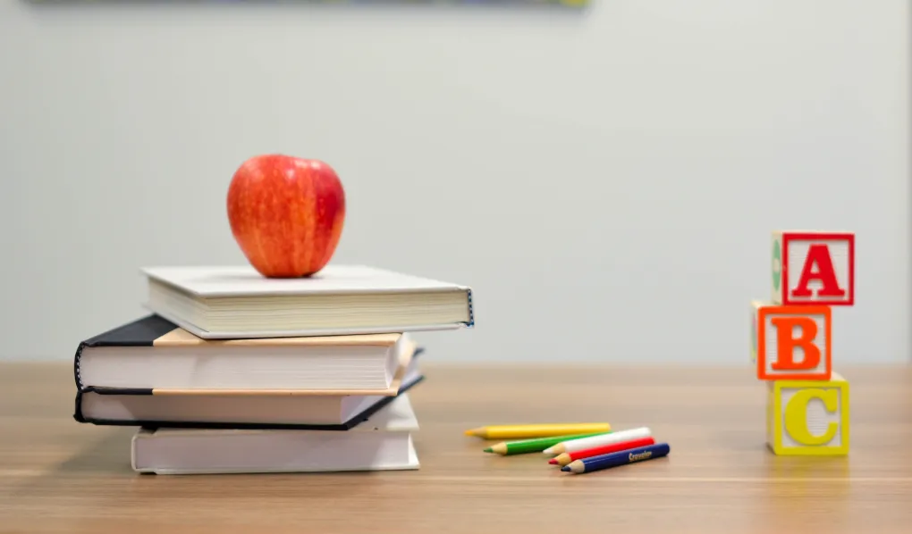 Books, pencils and ABC blocks on a table