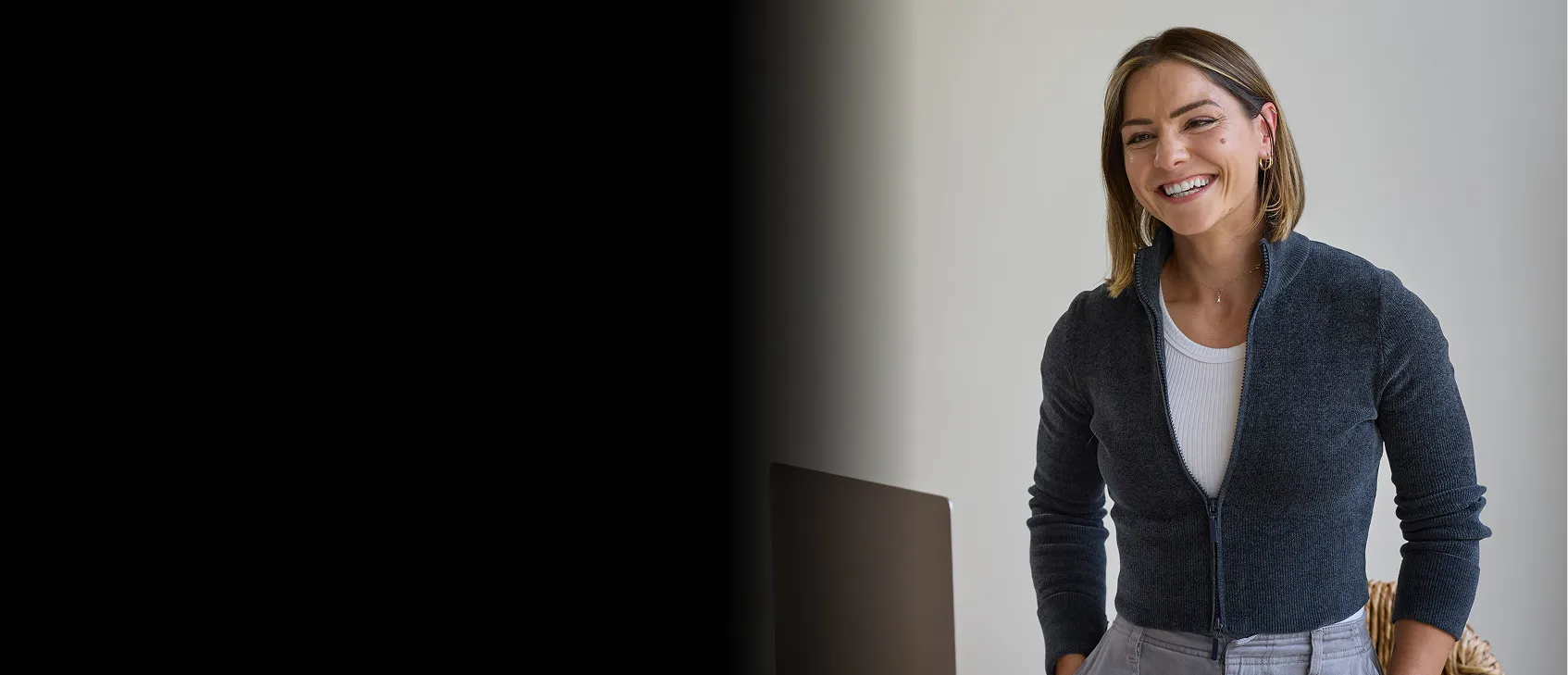 Smiling blond woman standing with her hands on her pockets