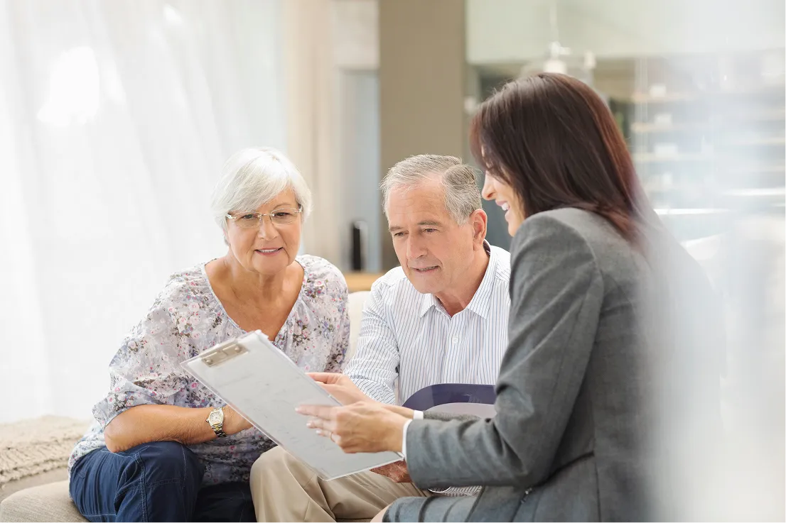 Young female explaining paperwork to older couple