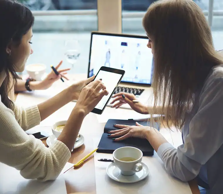 two-business-students-confer-over-work-in-cafe