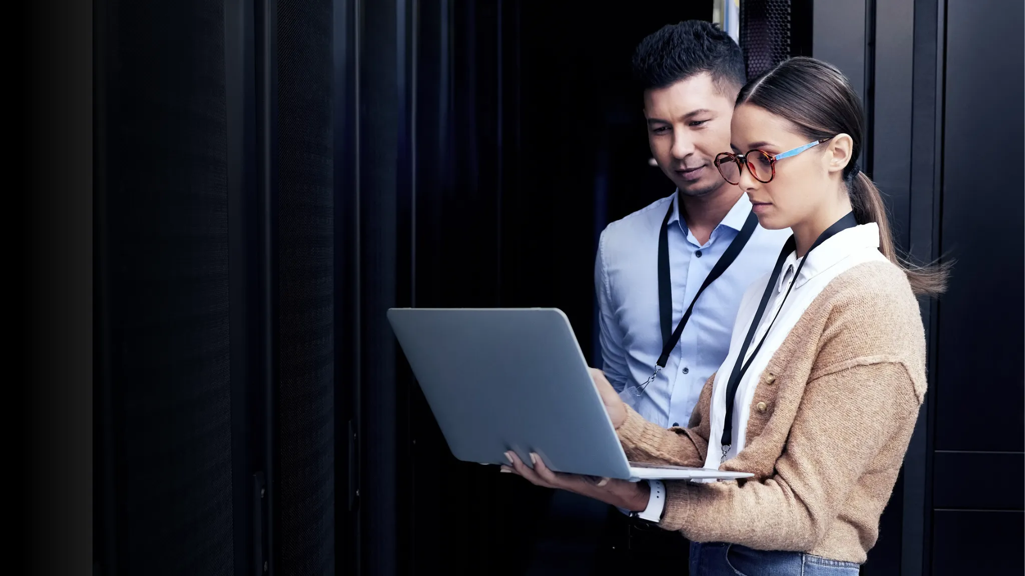 Male and female IT professionals looing at something on her laptop