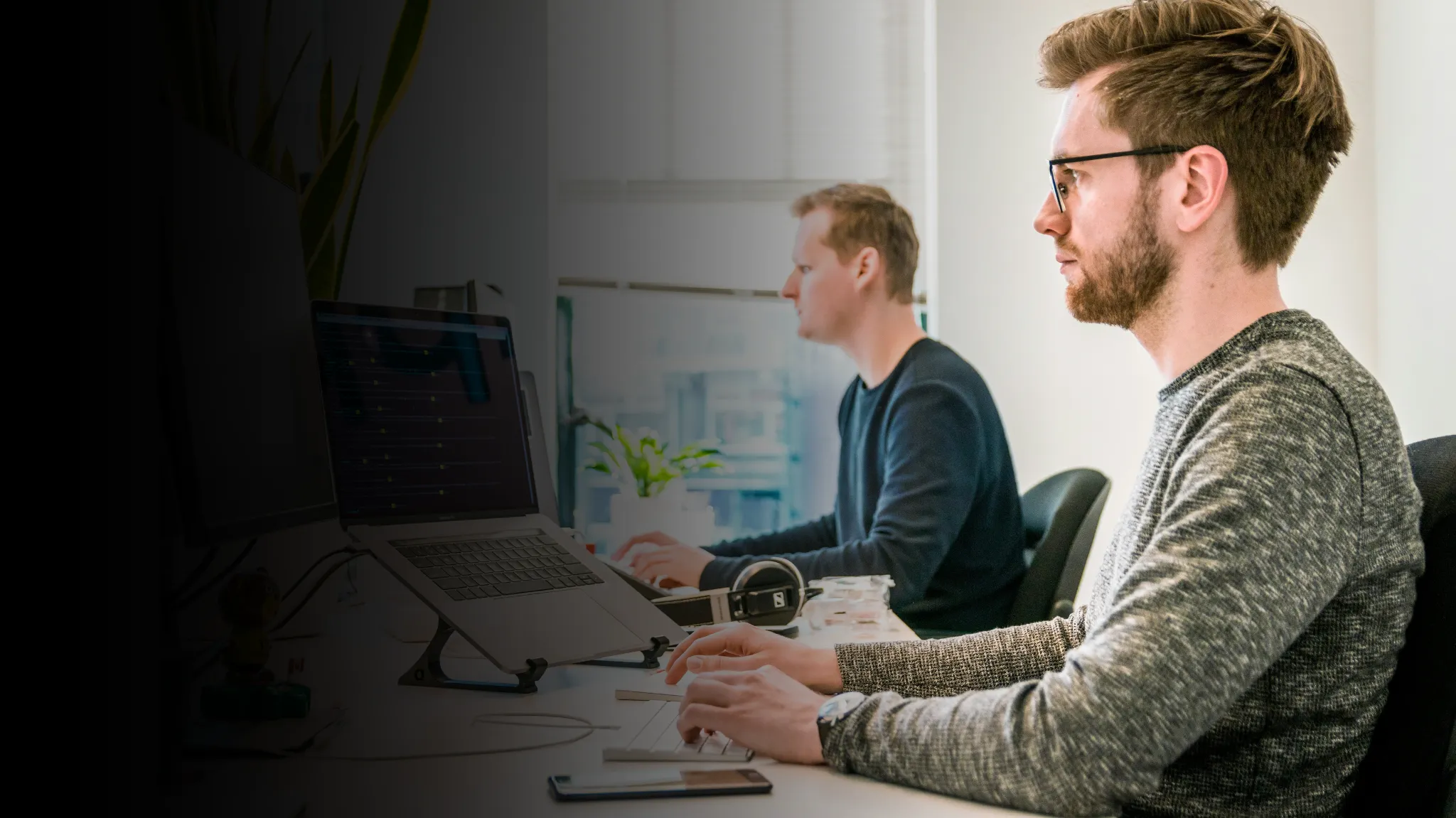 Two young men working on their laptops