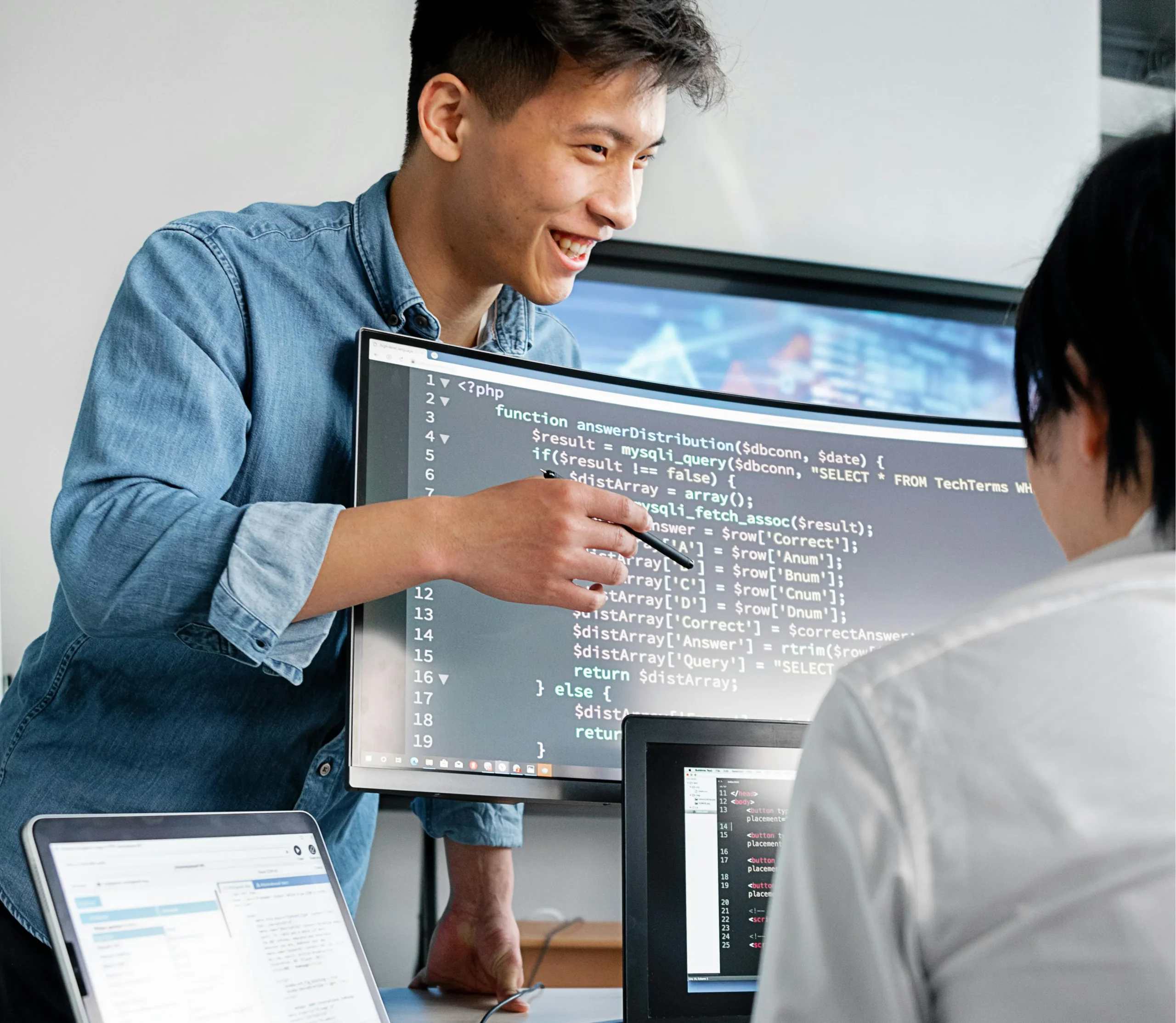 Young IT professional showing colleague something on their screen